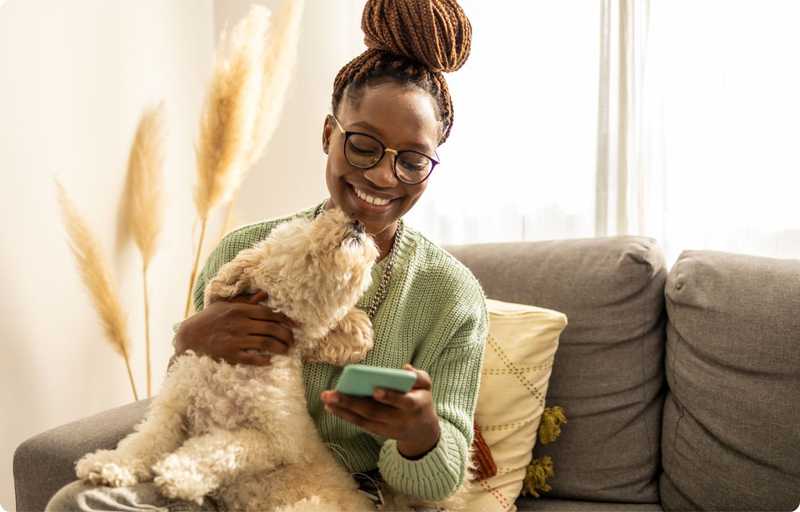 Woman holding a dog on the sofa