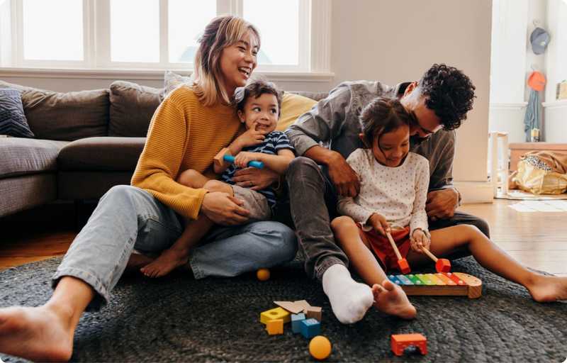 Family playing together next to a sofa