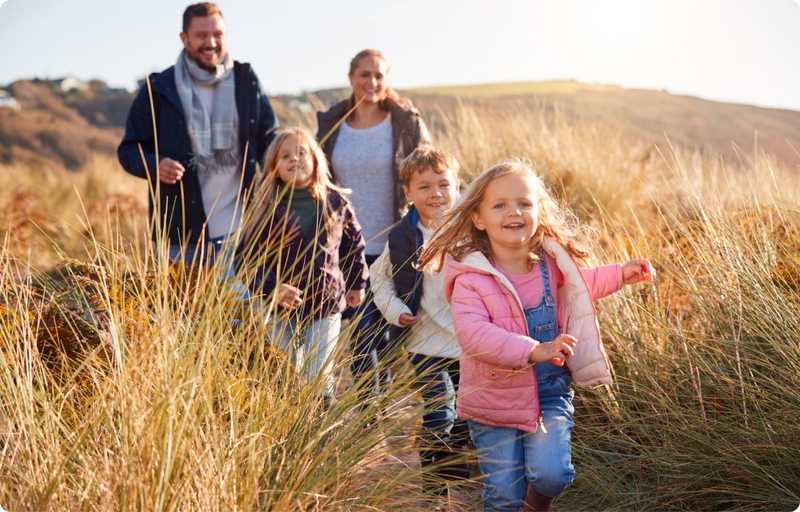 Family walking over a hill
