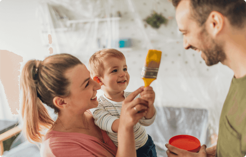 Woman holding child with paint brush